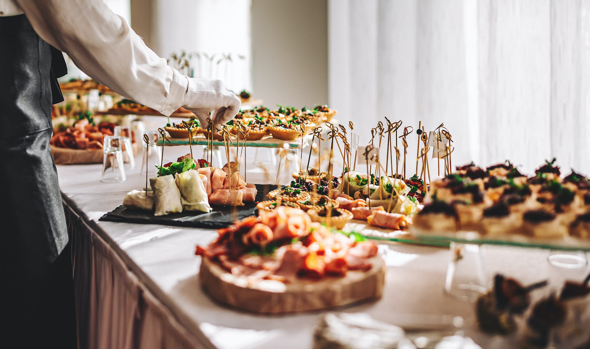 female hands of a waiter prepare food for a buffet table in a restaurant